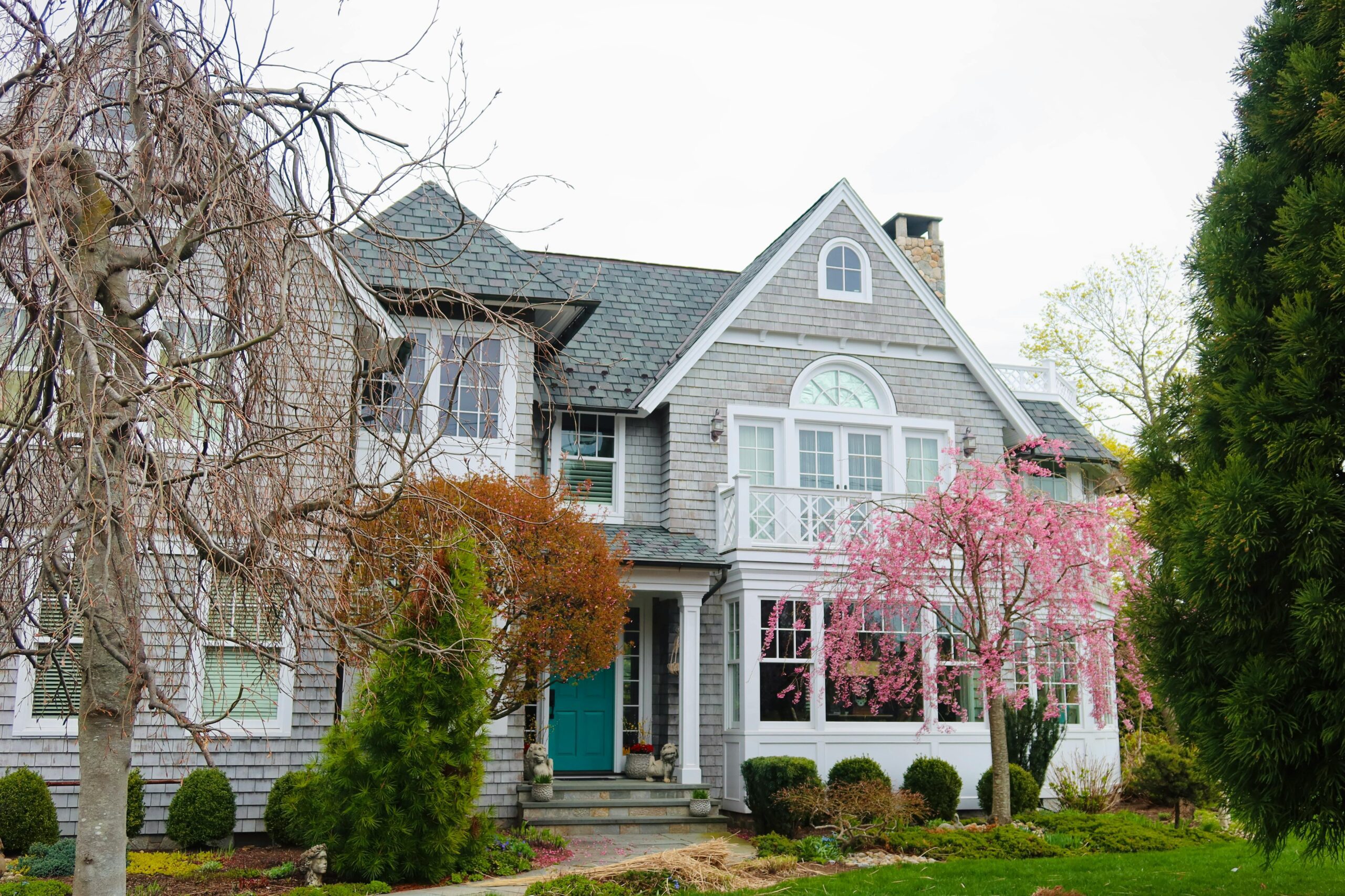 Beautiful suburban house with blooming spring trees and classic architecture.